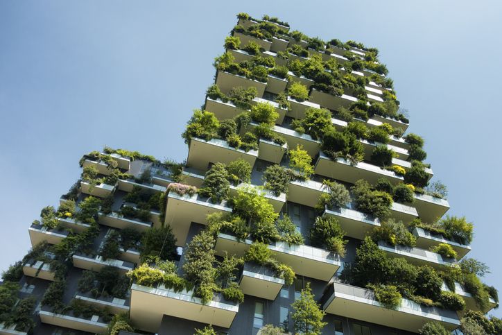 Hochhaus mit begrünten Balkonen Richtung Himmel fotografiert